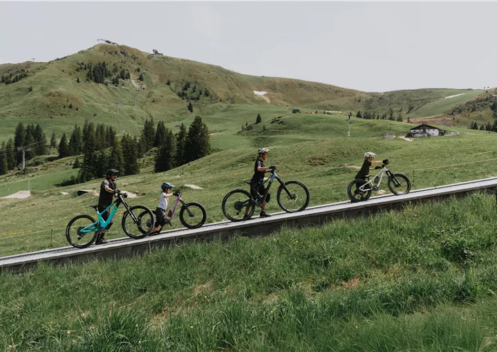 In der MTB Family Area Streiteck Mulde geht s mit dem Förderband gemütlich bergauf. Mini Jumpline im Hintergrund.